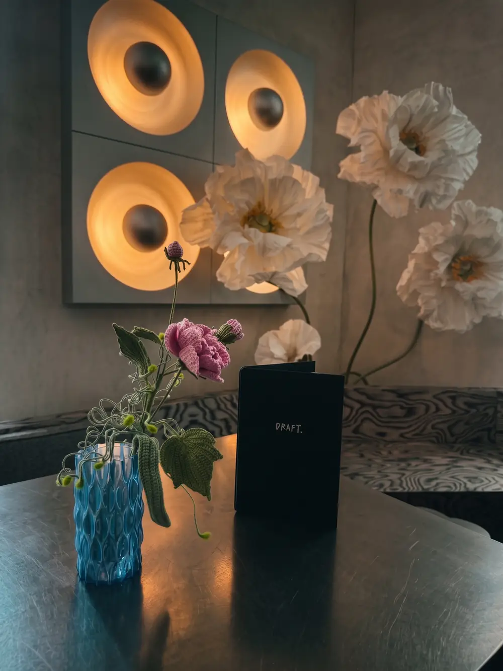 Hand-crocheted flowers in a vase at Draft Coffee